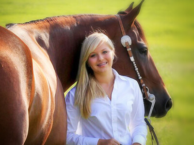 girl standing in front of shiny horse
